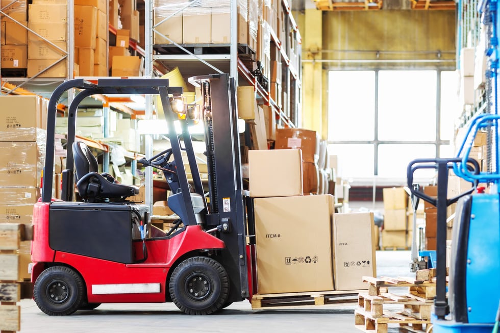 forklif  with a three large cardboard boxes in a modern warehous